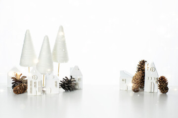 New Year's composition of white wooden houses and natural fir cones on a white background. Happy New Year greeting card! Merry Christmas. Trendy postcard made of natural materials. Winter town