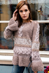Girl in a brown knitted sweater posing in the city of Riga
