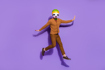 Fototapeta na wymiar Full body portrait of crazy anonymous red panda jumping flight isolated on violet color background