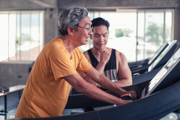 Fototapeta na wymiar Senior man and trainer man working out on exercise running on treadmill in gym center