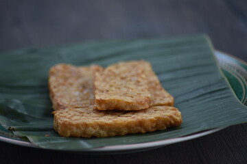 Tempeh or tempe is a traditional Javanese food made from fermented soybeans and made by a natural culturing and controlled fermentation process that binds soybeans into a cake form with a fungus