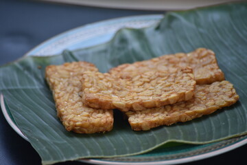Tempeh or tempe is a traditional Javanese food made from fermented soybeans and made by a natural culturing and controlled fermentation process that binds soybeans into a cake form with a fungus