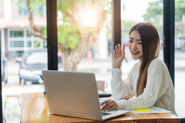 Freelance Asian woman working on tablet computers and financial graphs in a modern office. make an account analysis report real estate investment information financial and tax system concepts