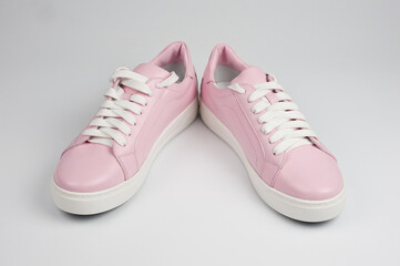 Light pink faux leather shoes laced with laces. Close-up shot.