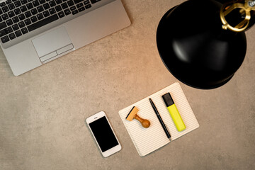 Home Office Pflicht, von zu Hause arbeiten, Arbeitsplatz mit Laptop, Handy, Notizblock und Leuchte