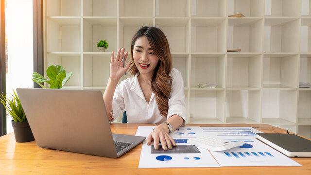 Freelance Asian woman working on tablet computers and financial graphs in a modern office. make an account analysis report real estate investment information financial and tax system concepts
