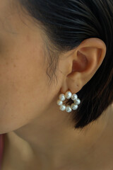 Detail of young woman wearing beautiful white pearl earring.