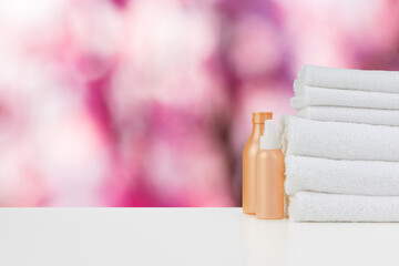 Spa still life with towels and skincare cosmetics against blurred background