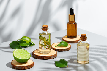 Fruit essential oil in glass bottle on gray background - obrazy, fototapety, plakaty