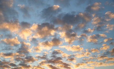 Dramatic sky with orange and gray clouds against a blue sky background