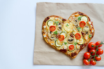 Heart shaped pizza with tomatoes, vegetables and cheese for Valentine's Day on background. Creative food concept of romantic love. Top view, flat lay.
