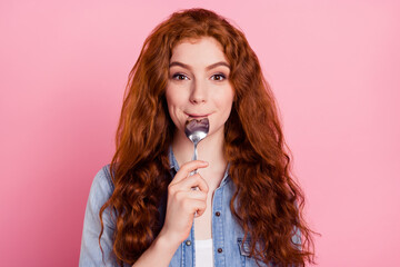 Photo of hungry adorable young woman wear denim shirt smiling licking spoon isolated pink color...