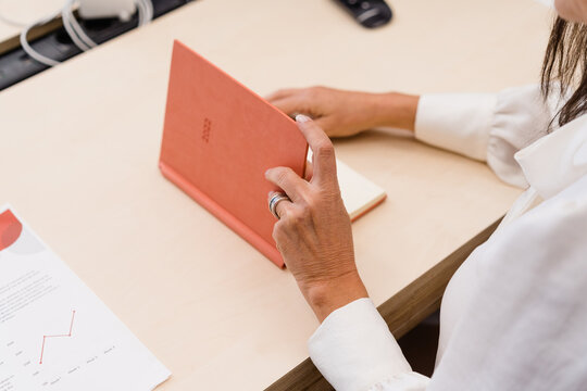 Unrecognizable woman with organizer on desktop