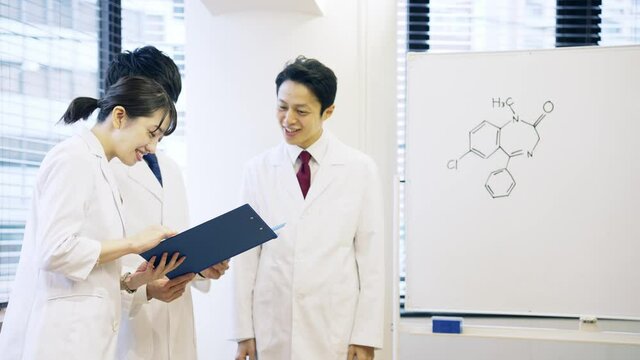 ミーティングする白衣を着た日本人グループ　医師　科学者