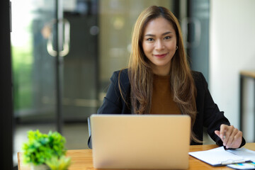 Happy business woman smile to camera while sitting at her desk