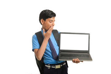 Indian school boy showing laptop screen on white background.