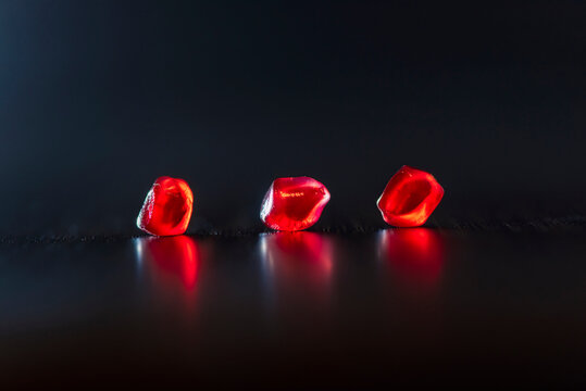 Red ripe juicy pomegranate fruits placed on black background