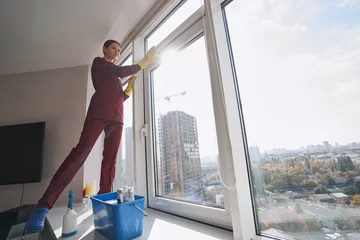Foto op Plexiglas Pensive housecleaner in rubber gloves wiping window-frame © Viacheslav Yakobchuk
