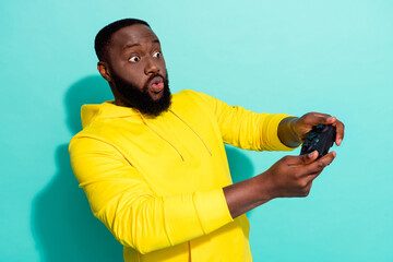 Photo of amazed addicted guy play console game speed race car crash isolated over cyan color background © deagreez