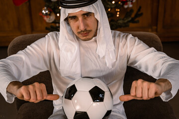 portrait of arab businessman showing a soccer ball in front of lights