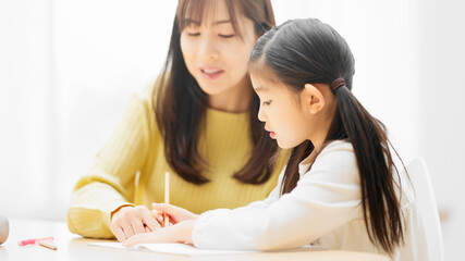 母親に勉強を教えてもらっている娘