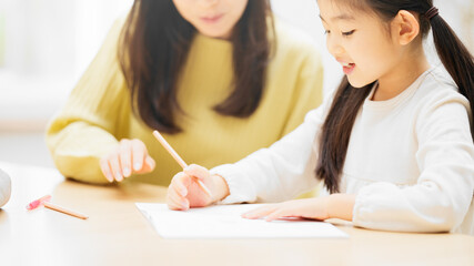 母親に勉強を教えてもらっている娘
