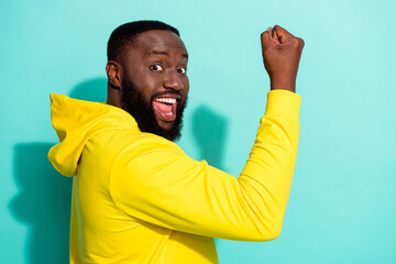 Fototapeta premium Profile photo of brunette cool young beard guy yell hand fist wear yellow hoodie isolated on teal color background