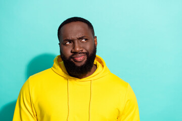 Photo of brunette unsure young beard guy look empty space wear yellow sports cloth isolated on...