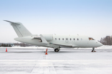 White luxury corporate business jet on the winter airport apron