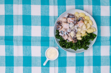 Gnocchi with vegetables and meat in a white sauce.