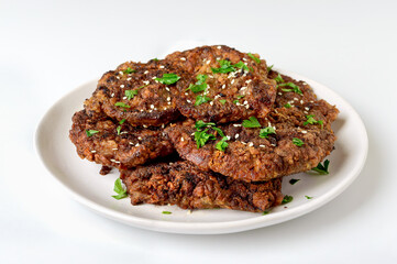 Juicy pieces of fried liver in batter on a plate on a white background. Close-up.