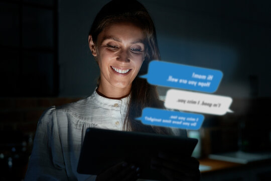 Smiling woman using smart phone at home during night