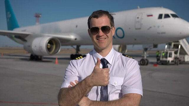 Airport, pilot airplane. Portrait of confident male pilot in uniform keeping arms crossed in background plane aircraft, Travel professional captain travelling transportation professions people concept
