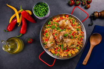 Arroz con pollo. Baked pieces of chicken with bone, rice with paprika and peas.