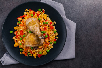 Arroz con pollo. Baked pieces of chicken with bone, rice with paprika and peas.