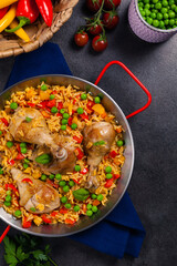 Arroz con pollo. Baked pieces of chicken with bone, rice with paprika and peas.