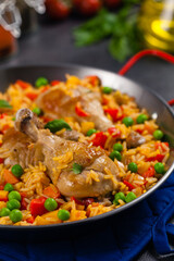 Arroz con pollo. Baked pieces of chicken with bone, rice with paprika and peas.