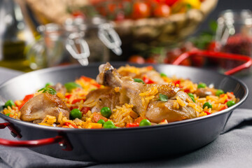 Arroz con pollo. Baked pieces of chicken with bone, rice with paprika and peas.