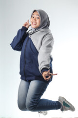 portrait of an Asian woman wearing casual clothes. hooded woman wearing gray jacket isolated on white background. levitation photo concept with happy expression
