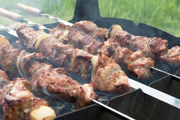 Marinated shashlik preparing on a barbecue grill over charcoal. Shashlik or Shish kebab popular in Eastern Europe. Shashlyk (skewered meat) was originally made of lamb. Roast Beef Kebabs On BBQ Grill.