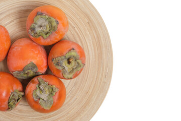 Persimmon fruit wooden plate on white background.