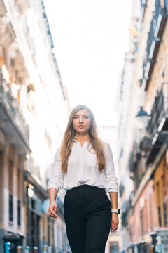 Beautiful young woman looking away while walking at alley