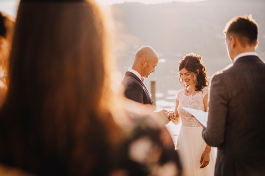Happy couple exchanging ring during wedding ceremony