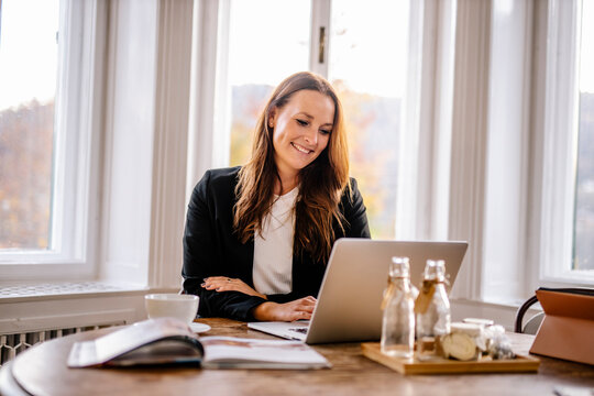 Businesswoman using laptop while sitting in office
