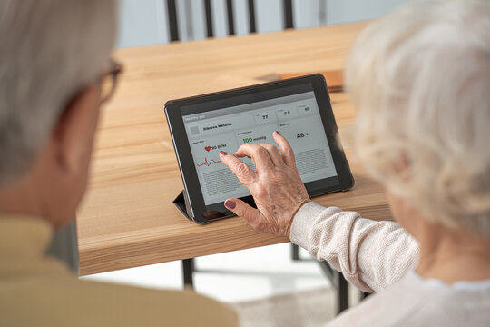 Retirement female person typing at the tablet screen while using special medicine app