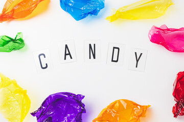 Colorful candy wrappers and text CANDY on white. Sugar sweets concept. Abstract colorful background