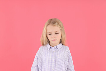 Resentful little girl in shirt on pink background