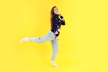 Fototapeta na wymiar Attractive young woman in Christmas sweater on yellow background