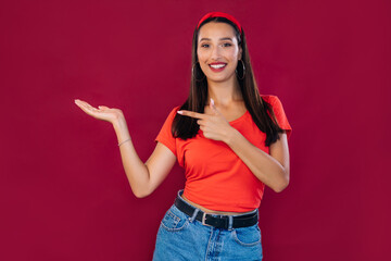 Excited young girl smiling and looking at the camera, pointing t