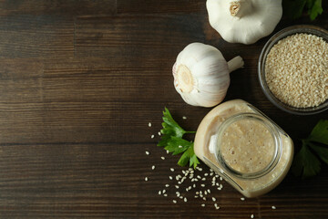 Concept of tasty food with tahini sauce on wooden background